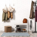 Stylish hallway interior with shoe rack and hanging clothes on b