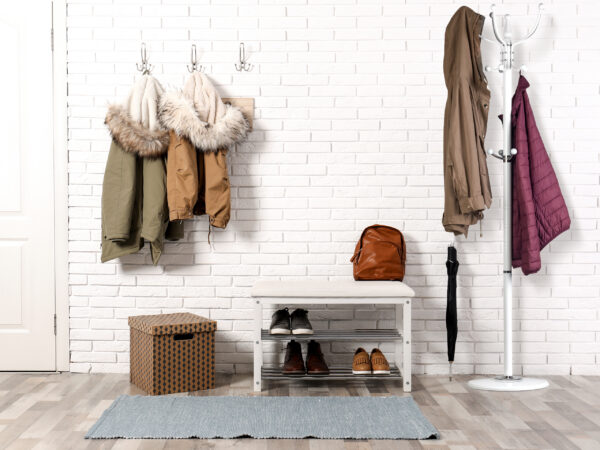 Stylish hallway interior with shoe rack and hanging clothes on b Stylish hallway interior with shoe rack and hanging clothes on b
