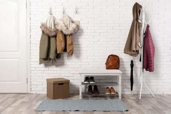 Stylish hallway interior with shoe rack and hanging clothes on b Stylish hallway interior with shoe rack and hanging clothes on b