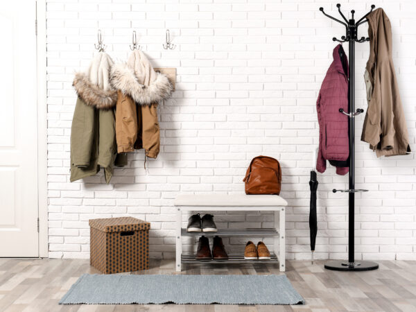 Stylish hallway interior with shoe rack and hanging clothes on b Stylish hallway interior with shoe rack and hanging clothes on b