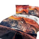 Lamp on wooden table next to a blue and white bed in bedroom int