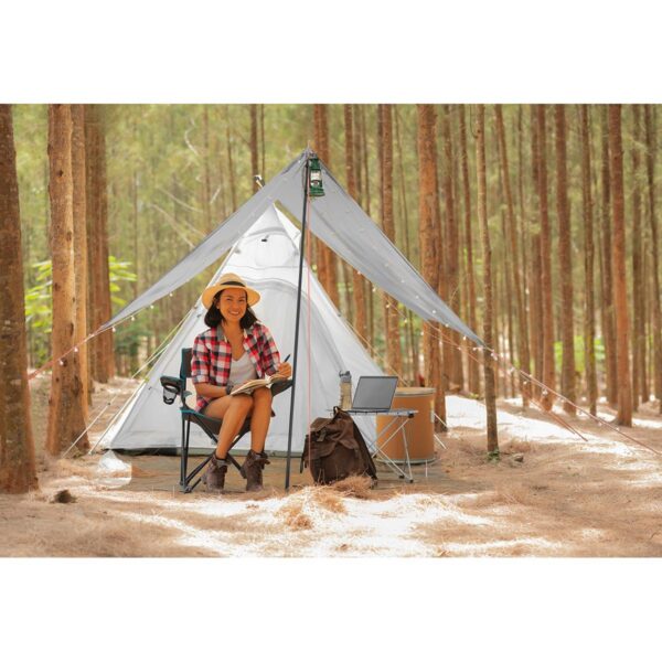 Young woman tourist sitting near the tent and reading a book. pe Young woman tourist sitting near the tent and reading a book. pe