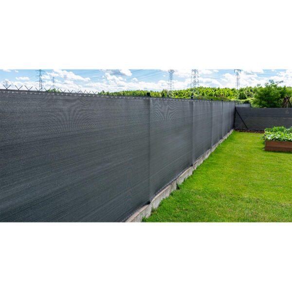 Anthracite-colored masking net placed on a mesh fence, visible vegetable boxes. Anthracite-colored masking net placed on a mesh fence, visible vegetable boxes.