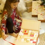 Meitene atver adventes kalendāru Merry Christmas